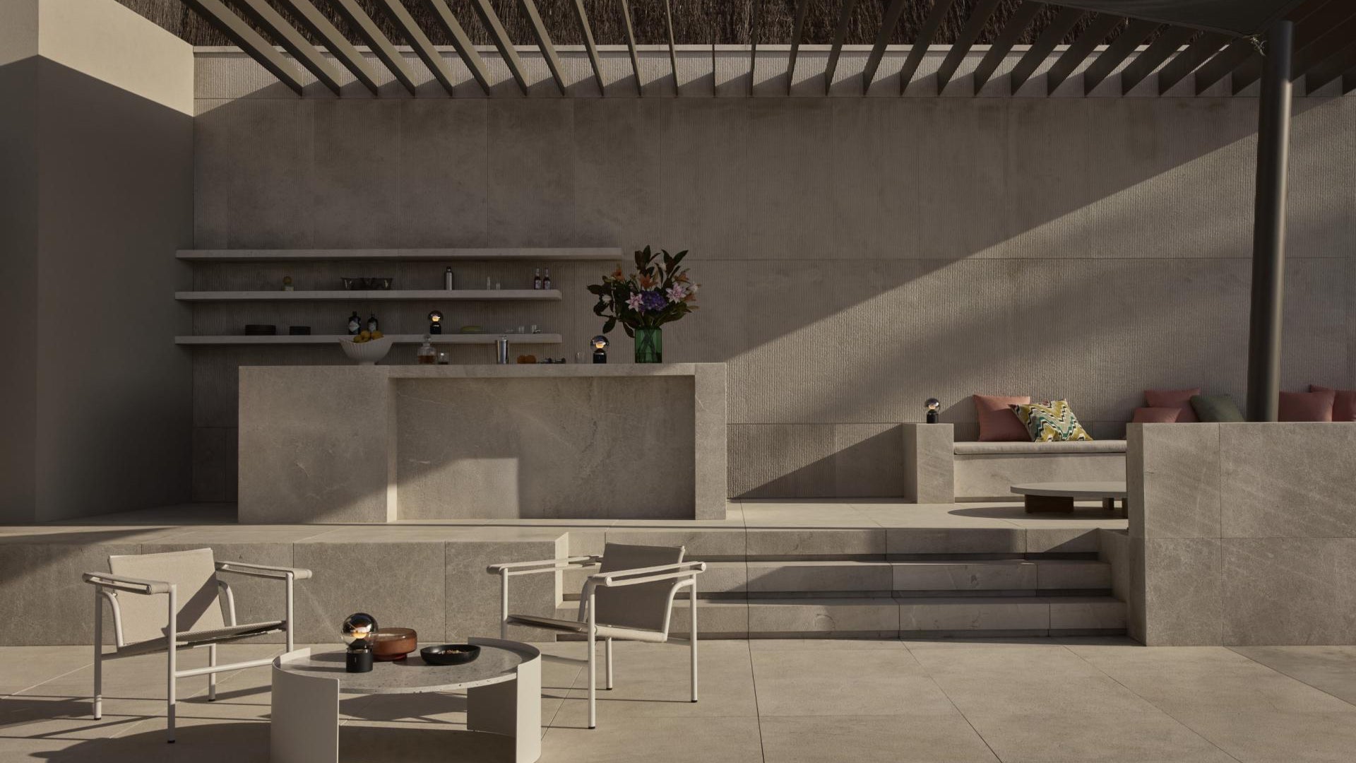 Modern outdoor patio with concrete walls, furniture, and decorative elements.